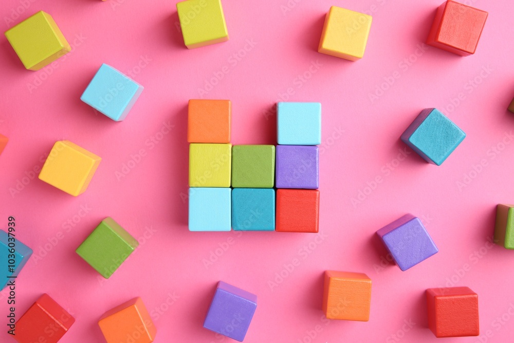 Many wooden colorful cubes on pink background, top view Many wooden colorful cubes on pink background, top view