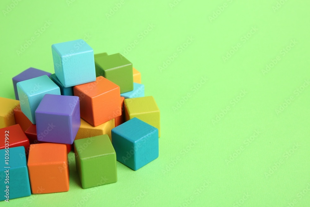 Many wooden colorful cubes on green background, space for text Many wooden colorful cubes on green background, space for text
