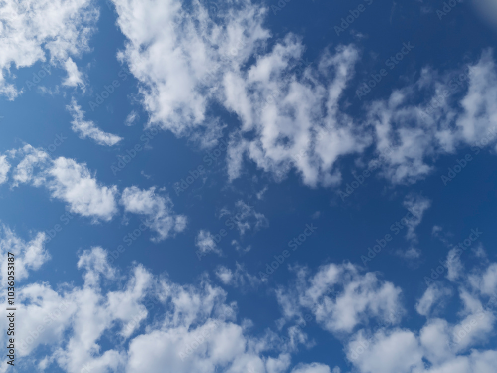 Obraz premium Beautiful blue sky with fluffy white clouds, creating a serene and peaceful atmosphere for relaxation and inspiration.