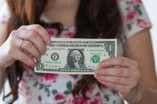 Woman hands giving 1 US dollar banknote