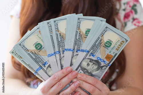 Woman hands holding pile of 100 US dollar banknotes