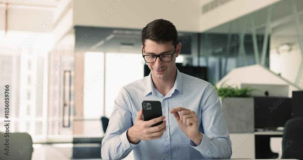 Business activity, connectivity, mobile technology. Man using smartphone in modern office environment, review, respond to work-related emails, search information, manage business social media account Business activity, connectivity, mobile technology. Man using smartphone in modern office environment, review, respond to work-related emails, search information, manage business social media account