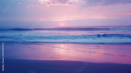 A soft and grainy gradient of moody blues and purples fade into a serene and sandy beach mirroring the beauty of a grainy ocean sunset.