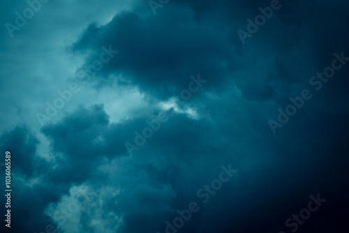 Moody dark clouds swirling in the stormy evening sky.