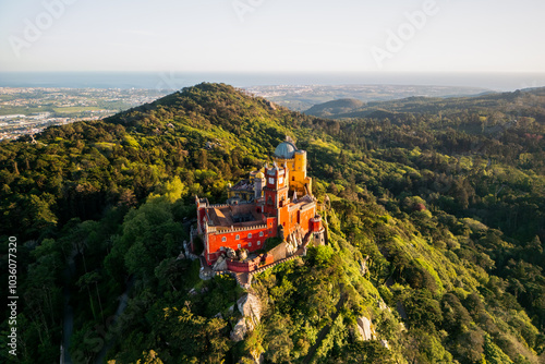 Fotografie Aerial view of Pena Palace in Sintra, Portugal a Romanticist castle on hilltop surrounded by forest during sunset