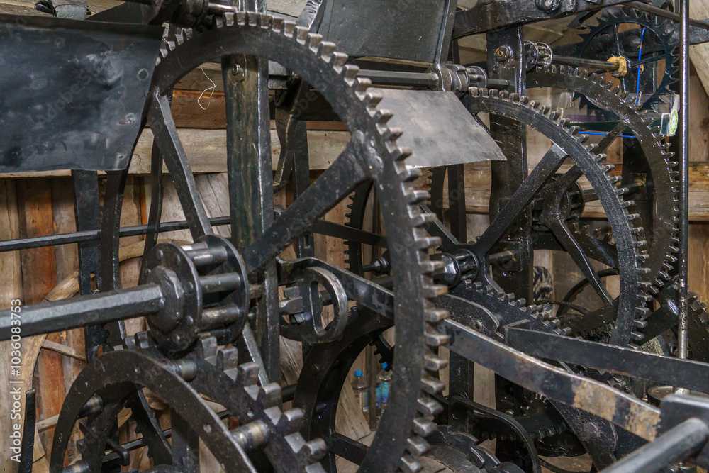 Church clockwork. The gear mechanism of a large old tower clock. Antique large clock mechanism with gears and cogs after restoration Church clockwork. The gear mechanism of a large old tower clock. Antique large clock mechanism with gears and cogs after restoration