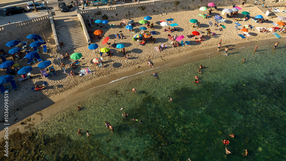Aerial view of the city beach in the center of Santa Maria di Leuca in Salento, Puglia, Italy. It is a small sandy beach with tourists bathing. Aerial view of the city beach in the center of Santa Maria di Leuca in Salento, Puglia, Italy. It is a small sandy beach with tourists bathing.
