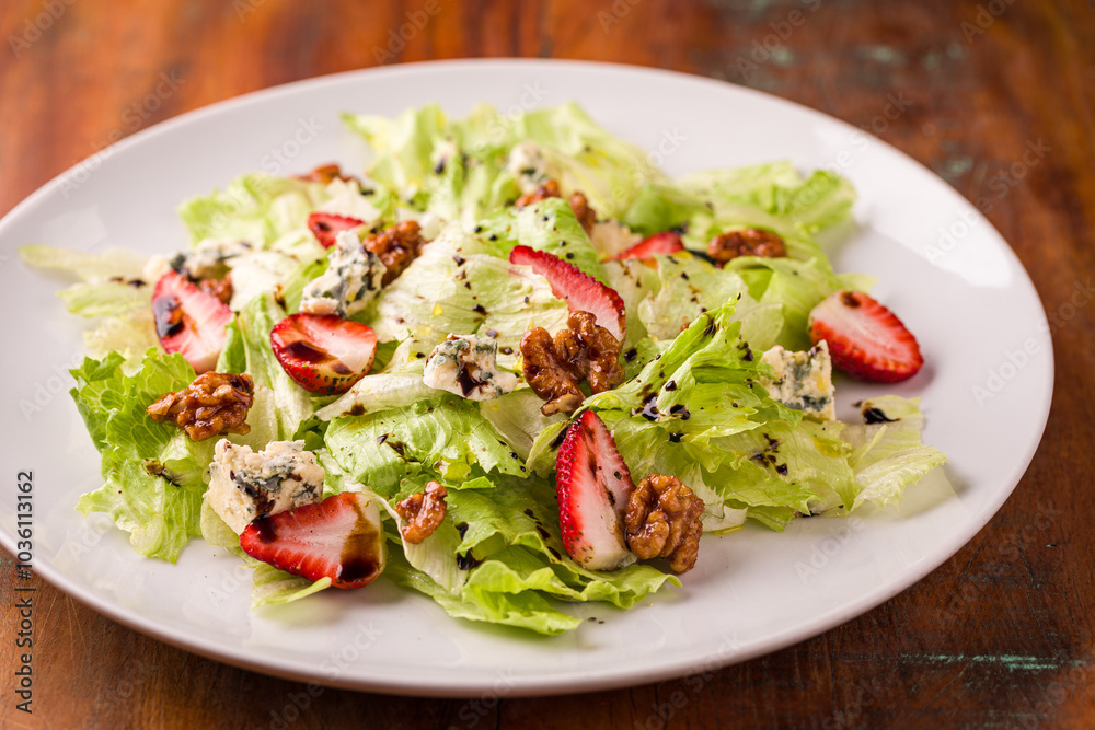 Fresh Green Salad with Strawberries and Walnuts on White Plate Fresh Green Salad with Strawberries and Walnuts on White Plate