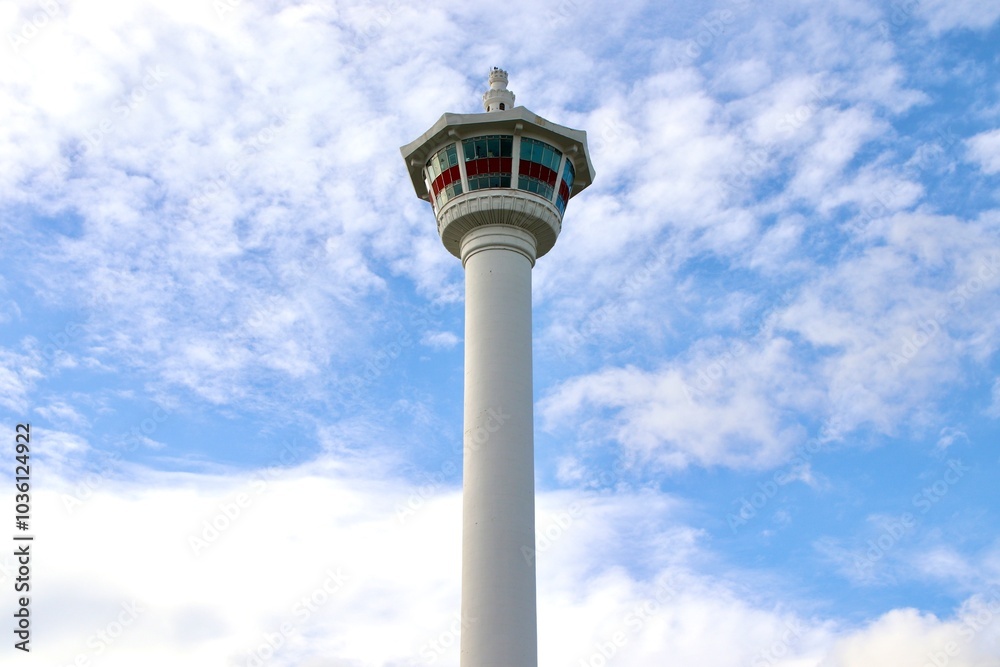 Low Angle View of Busan Tower Against Cloudy Blue Sky with Ample Copy Space. Minimalistic Shot Low Angle View of Busan Tower Against Cloudy Blue Sky with Ample Copy Space. Minimalistic Shot