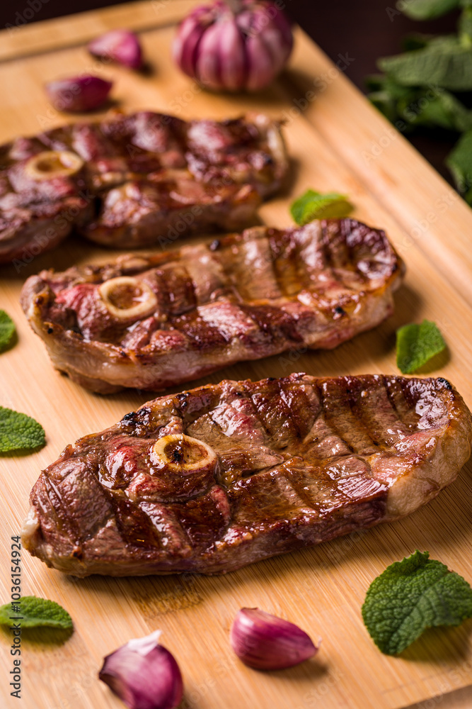 Grilled Lamb Chops With Garlic And Mint On Wooden Board Grilled Lamb Chops With Garlic And Mint On Wooden Board