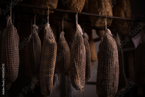 Fotografie Traditional Sausages Hanging in a Dark Curing Room