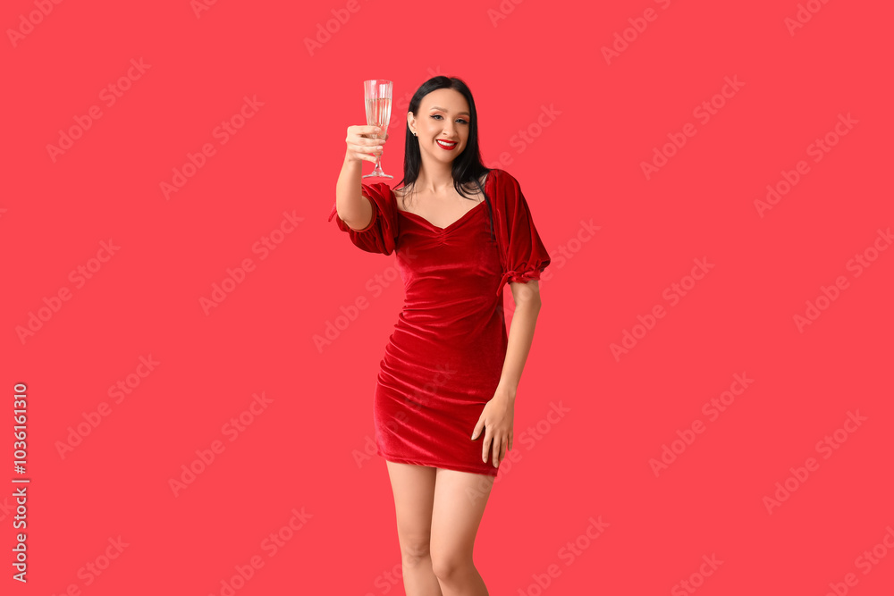 Beautiful young woman with glass of champagne on red background Beautiful young woman with glass of champagne on red background