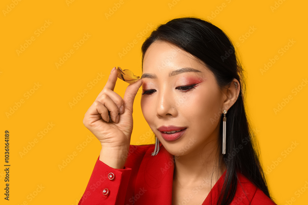 Beautiful young Asian woman with boat on yellow background. Chinese New Year celebration Beautiful young Asian woman with boat on yellow background. Chinese New Year celebration
