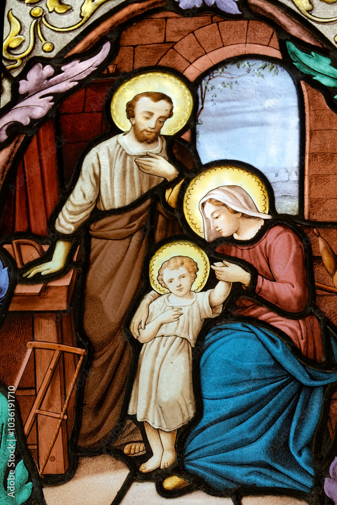 2024-10-14, Paris, FRANCE. Stained glass (19th century) of Holy family: Jesus infant, Virgin Mary and St Joseph in the workshop of Joseph the carpenter. 2024-10-14, Paris, FRANCE. Stained glass (19th century) of Holy family: Jesus infant, Virgin Mary and St Joseph in the workshop of Joseph the carpenter.