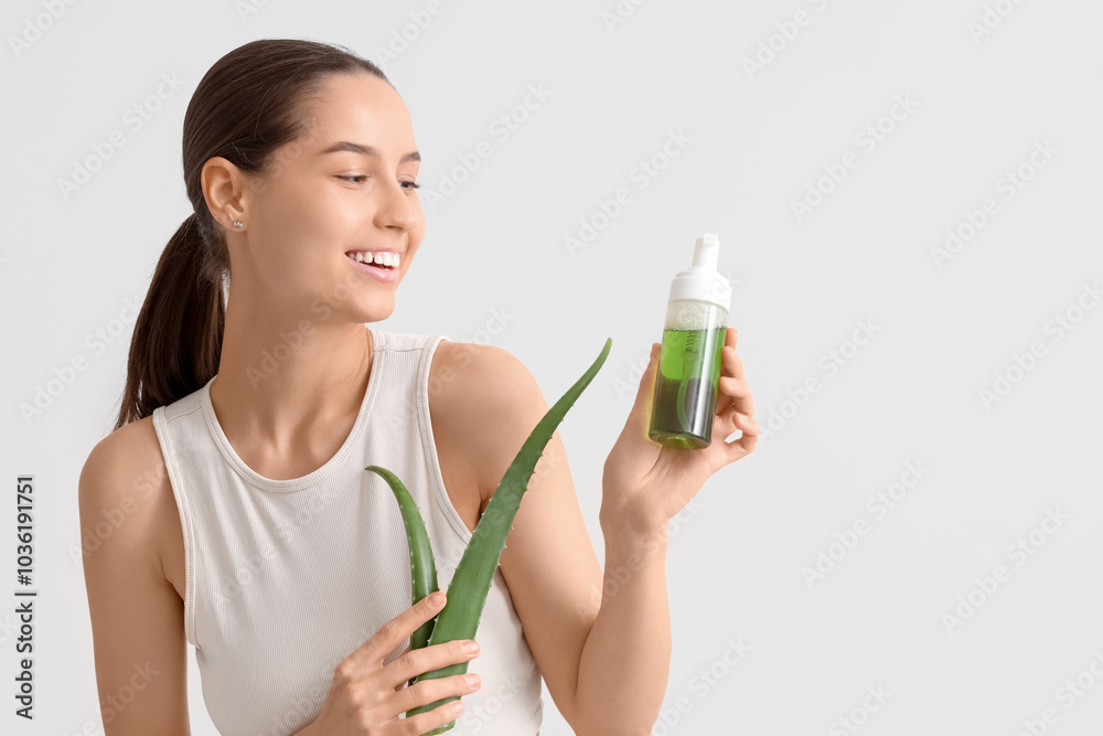 Beautiful young happy woman with plant leaf and bottle of aloe vera spray on white background Beautiful young happy woman with plant leaf and bottle of aloe vera spray on white background