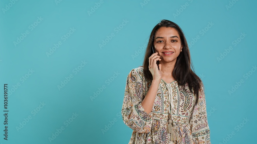 Indian woman discussing with best friend over telephone call using smartphone. Cheerful person talking with mate in phone call using cellphone, isolated over studio background, camera A Indian woman discussing with best friend over telephone call using smartphone. Cheerful person talking with mate in phone call using cellphone, isolated over studio background, camera A