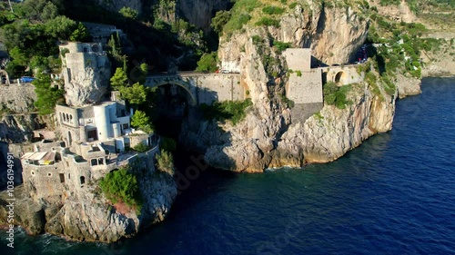 4K Aerial view of very unique bridge over a beach in narrow cliffs on a beautiful sunny day. Famous tourist attraction Fiordo di Furore on the picturesque Amalfi coast in Italy