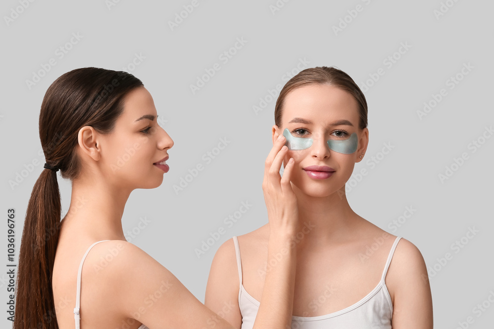 Beautiful young happy woman with healthy skin and under-eye patches on grey background Beautiful young happy woman with healthy skin and under-eye patches on grey background