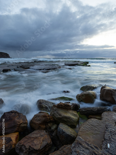 Cloudy morning view on the rocky beach shore.