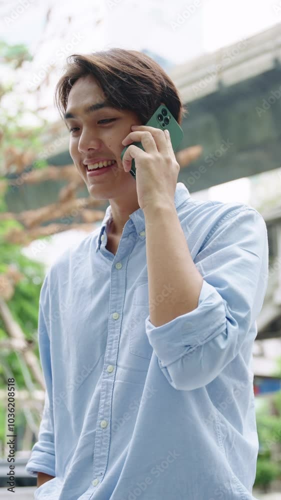 Young man smiling talking on phone in slow motion - Bangkok Thailand Young man smiling talking on phone in slow motion - Bangkok Thailand