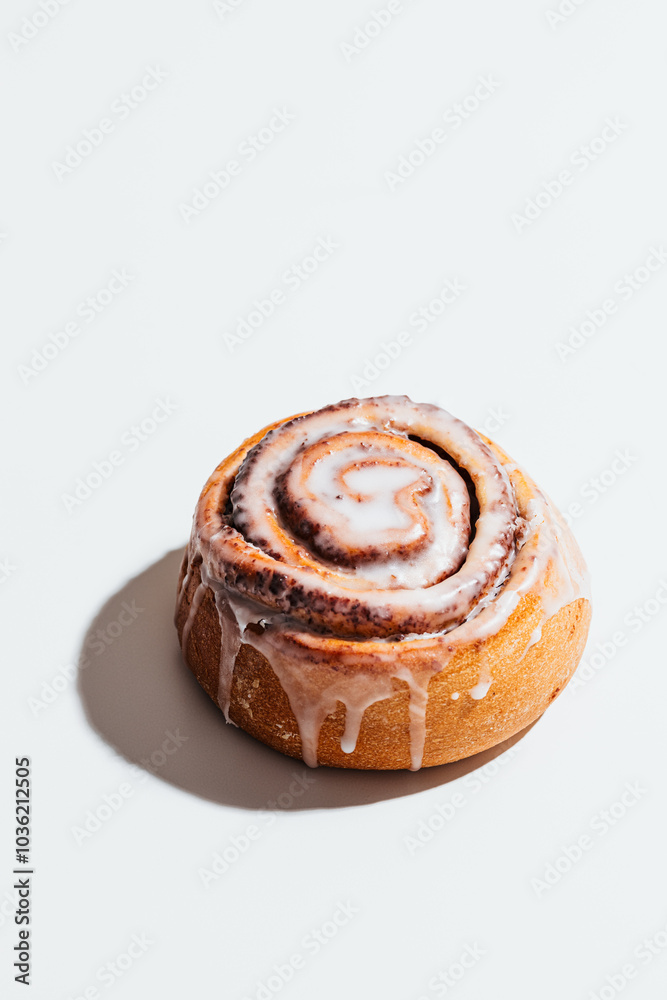Fresh cinnamon roll with creamy icing on white background