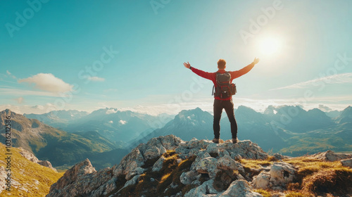 Sucessful Man with backpack stand on a top of a mountain and raise his arms