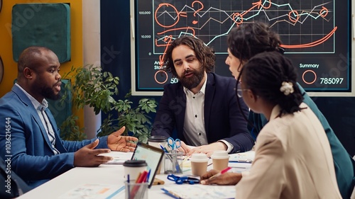 Tableau sur toile Startup team evaluating infographics data in an executive meeting, corporate restructuring or organizational changes