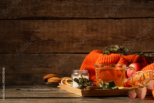 Composition with tray, cup of green tea and sweater on wooden table