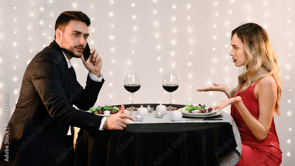 Relationship Problems. Angry Young Woman Blaming Her Busy Boyfriend Talking On Phone During Romantic Dinner In Restaurant, Side View Relationship Problems. Angry Young Woman Blaming Her Busy Boyfriend Talking On Phone During Romantic Dinner In Restaurant, Side View