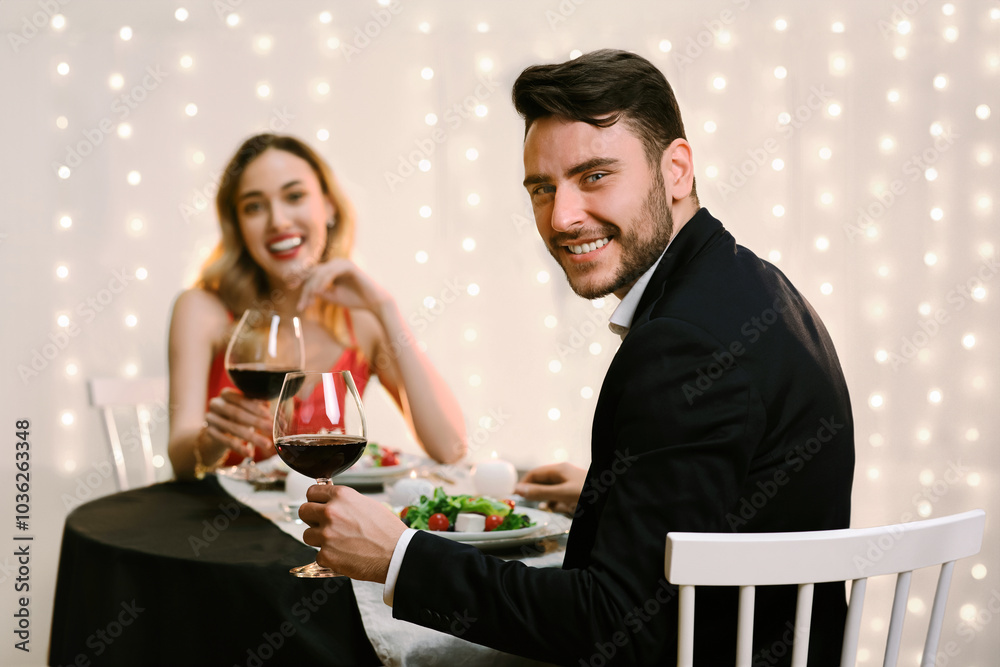 Beautiful young couple with glasses of red wine on romantic date in restaurant, celebrating anniversary or valentine's day together, selective focus Beautiful young couple with glasses of red wine on romantic date in restaurant, celebrating anniversary or valentine's day together, selective focus