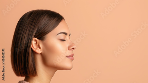 A serene portrait of a young woman with closed eyes, exhibiting a chic khaki outfit against a soft beige backdrop.