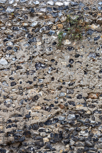 Full frame abstract texture background of a rustic medieval flint and mortar stone wall
 photo