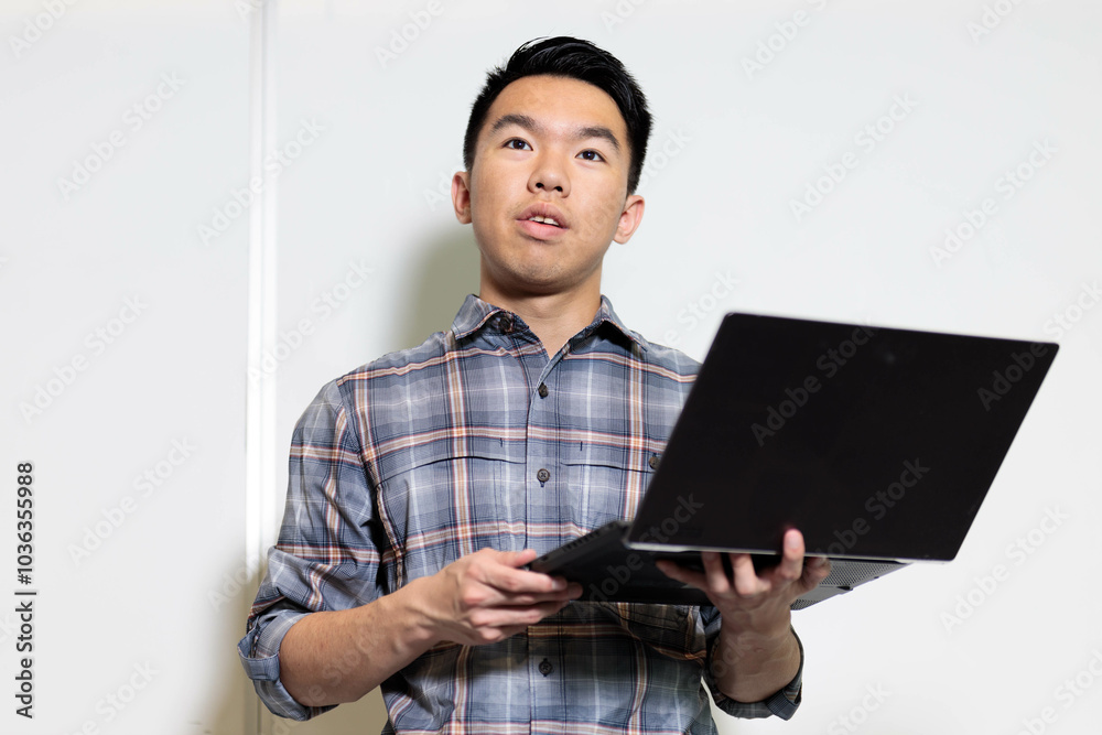 Closeup of a student giving a presentation with his laptop in front of the classroom Closeup of a student giving a presentation with his laptop in front of the classroom