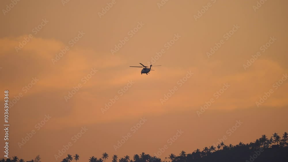 Military helicopter flying. Helicopter flying over a sunset landscape during a calm evening in a remote area Military helicopter flying. Helicopter flying over a sunset landscape during a calm evening in a remote area