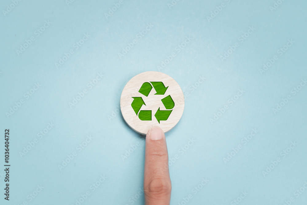 Ecosystem restoration, environment day concept. Hand touching recyclable symbol on circular wooden block. ecological waste management and sustainable development. Ecosystem restoration, environment day concept. Hand touching recyclable symbol on circular wooden block. ecological waste management and sustainable development.