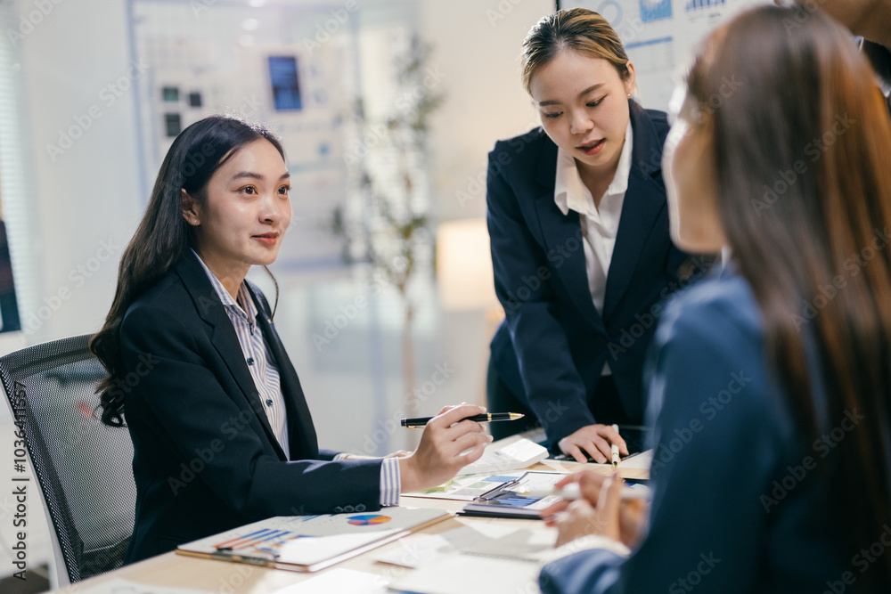Team of asian businesswomen are having a meeting in a modern office, discussing financial data and using a calculator Team of asian businesswomen are having a meeting in a modern office, discussing financial data and using a calculator