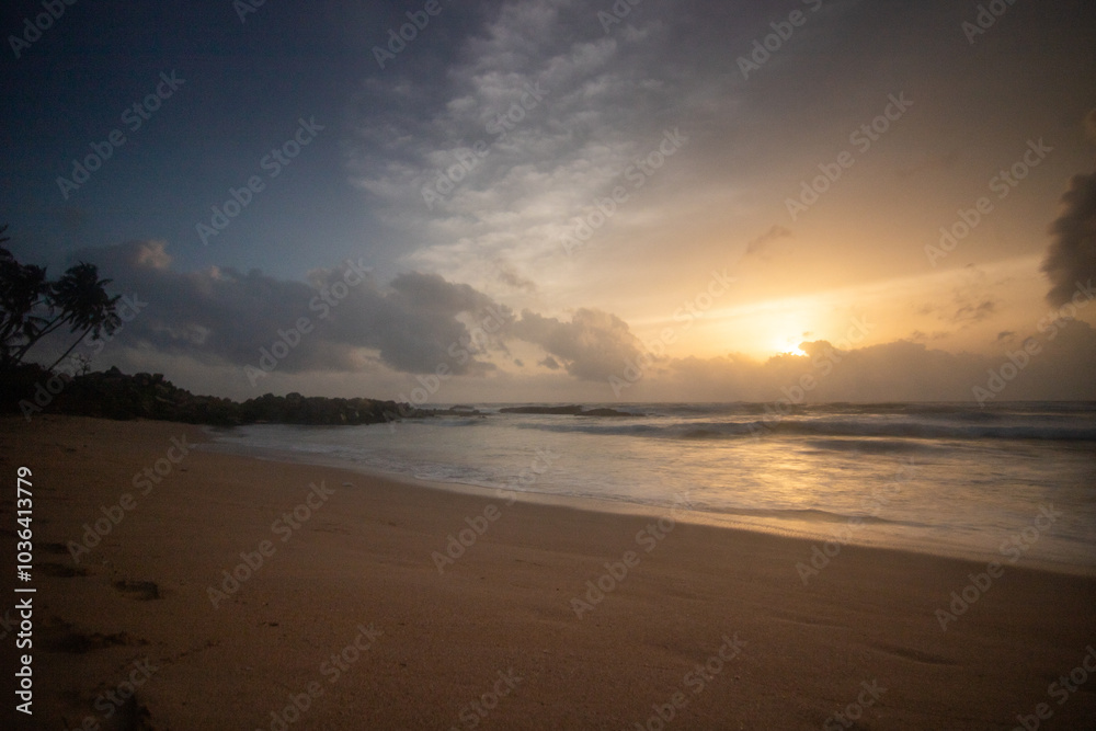Landscape by the sea. Long deserted beach with water views to the horizon. The waves of a storm break on the sand and give the picture a special touch at sunset. ´ Bentota, Sri Lanka, Asia Landscape by the sea. Long deserted beach with water views to the horizon. The waves of a storm break on the sand and give the picture a special touch at sunset. ´ Bentota, Sri Lanka, Asia