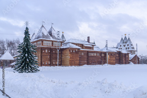 The wooden royal palace, built in the village of Kolomenskoye near Moscow in the second half of the XVII century. Wooden architecture. Christmas tree next to the log palace in winter in Moscow photo