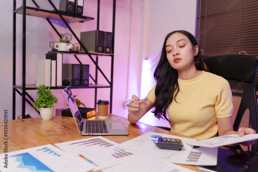 Asian woman sitting at work, busy with documents, stressed face, busy with work. Asian woman sitting at work, busy with documents, stressed face, busy with work.