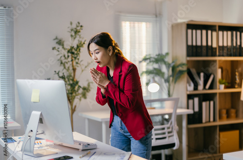 Young businesswoman in her office, looking shocked while reading an email on her computer, showing concern and worry. The image captures stress in a corporate setting