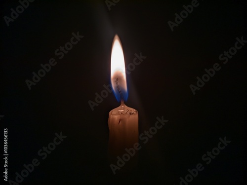 A single unlit candle stands tall against a pitch black background The candle is white with a slightly yellow hue  and its wick is long and straight The image is simple yet striking with the candles