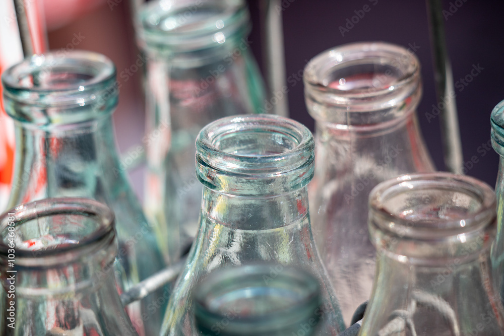 A row of empty glass bottles with the tops removed A row of empty glass bottles with the tops removed