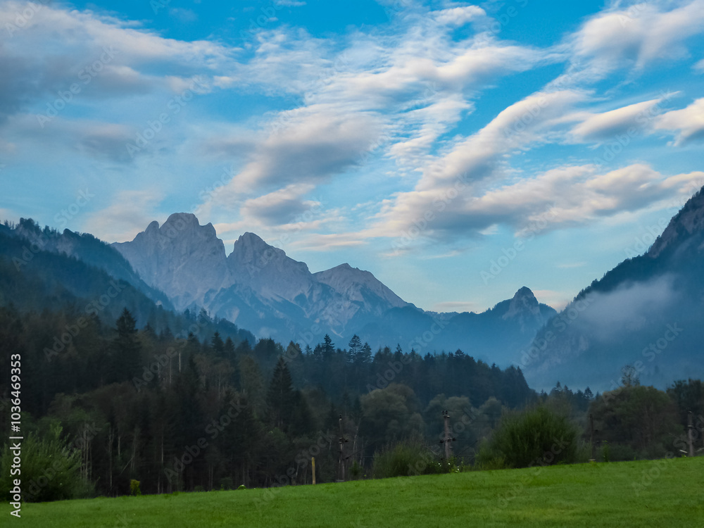 Panoramic view of majestic mountain range of Gesäuse, Ennstal Alps, Styria, Austria. Towering, jagged peaks rise up in Austrian Alps. Dense alpine forests cover the hillsides. Wanderlust in summer Panoramic view of majestic mountain range of Gesäuse, Ennstal Alps, Styria, Austria. Towering, jagged peaks rise up in Austrian Alps. Dense alpine forests cover the hillsides. Wanderlust in summer