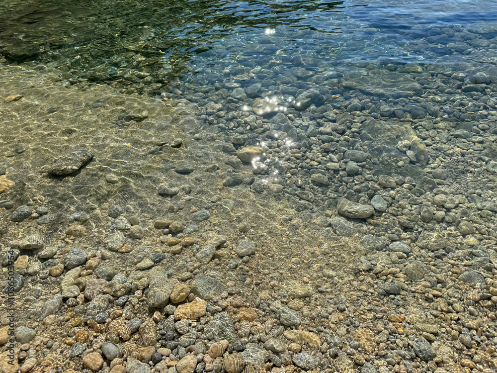 Sea clear water with pebbles and smooth stones on the shore Sea clear water with pebbles and smooth stones on the shore