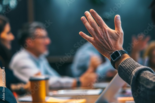 Colleagues in a collaborative meeting, one member raising a hand to propose a compromise.