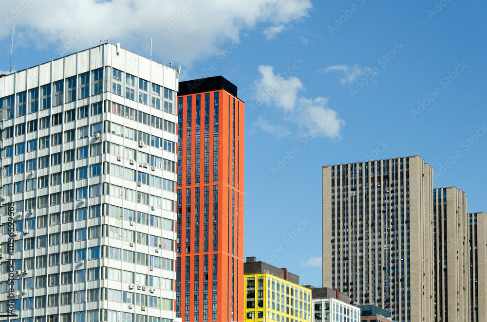 Naklejka premium modern high-rise buildings with different architectural styles against background of clear blue sky.