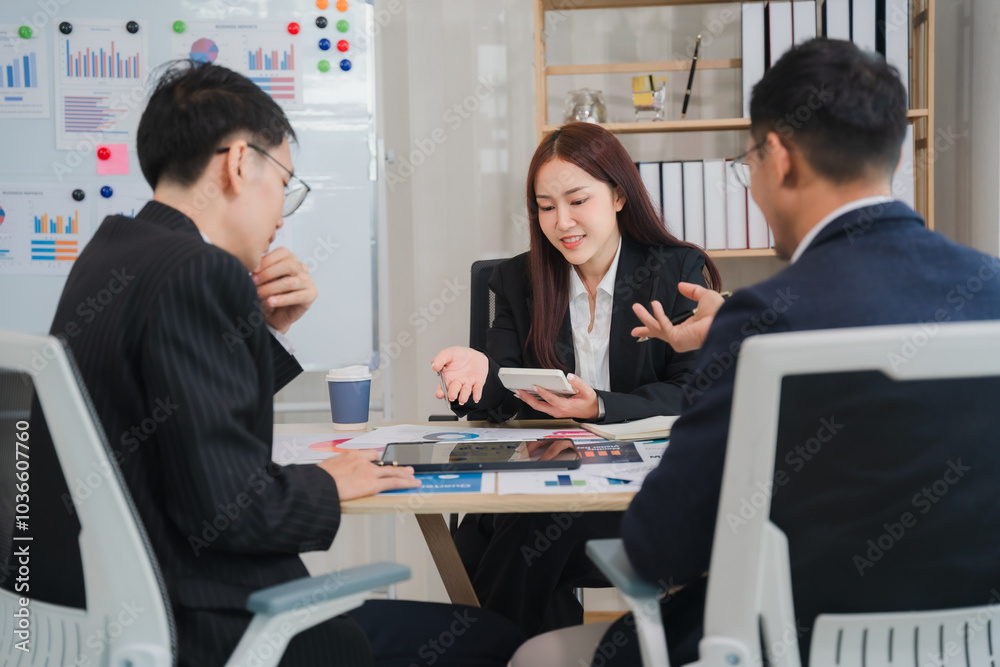 Strategic Business Meeting: A focused team of Asian business professionals collaborates around a table, engaging in a productive discussion and reviewing data. Strategic Business Meeting: A focused team of Asian business professionals collaborates around a table, engaging in a productive discussion and reviewing data.