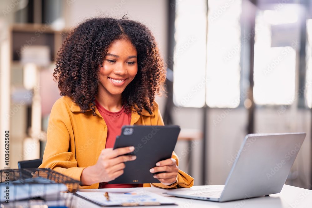 Beautiful professional woman sitting at table smiling while reading important documents with financial graphs and accounting of company. Beautiful professional woman sitting at table smiling while reading important documents with financial graphs and accounting of company.