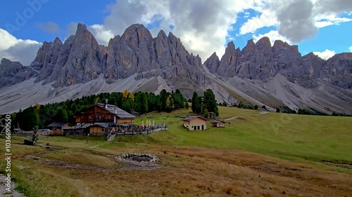 Geisler Alm Odle mountain, Alto Adige, Dolomites, Italy, where majestic mountains meet serene pastures. Witness the rustic charm of a mountain lodge surrounded by towering peaks and vibrant nature. photo