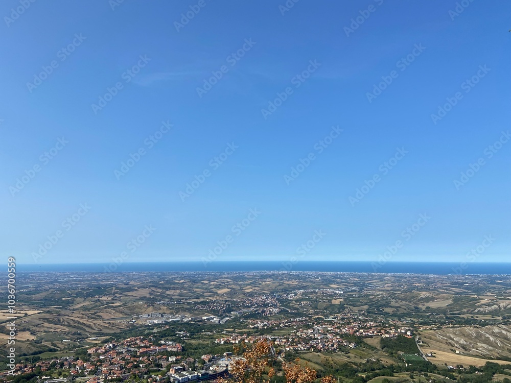 An amazing natural panorama of the San Marino suburbs surrounded by an endless blue sea strip on the horizon. An amazing natural panorama of the San Marino suburbs surrounded by an endless blue sea strip on the horizon.